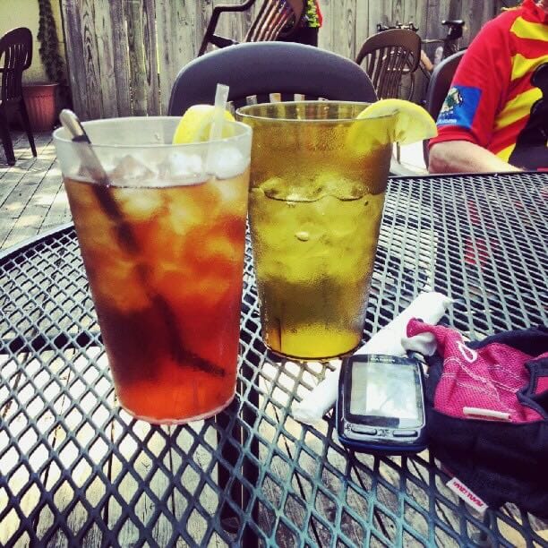 Color photo of two cold large drinks sitting on a table.