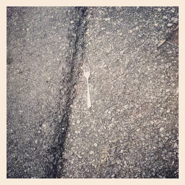 B&W photo of a fork lying in the road.
