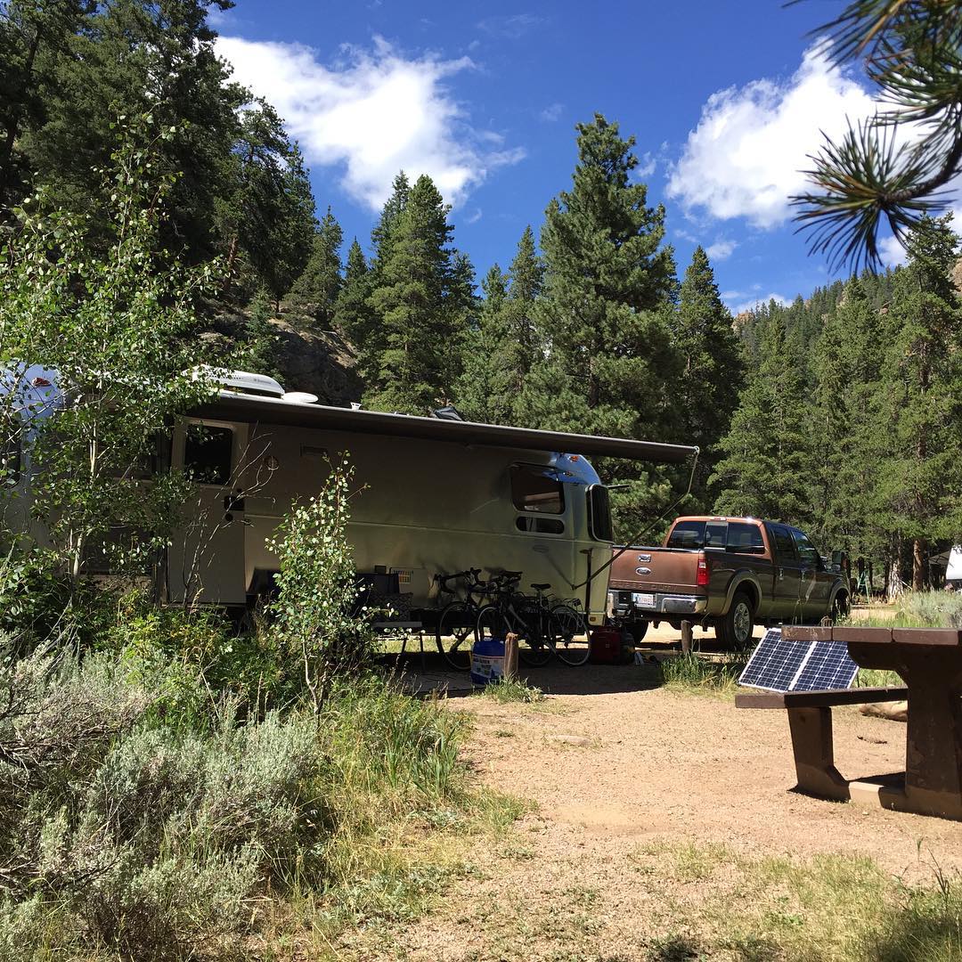Color photo of our Aistream at the North Bank Campground wtih Solar Panel deployed.