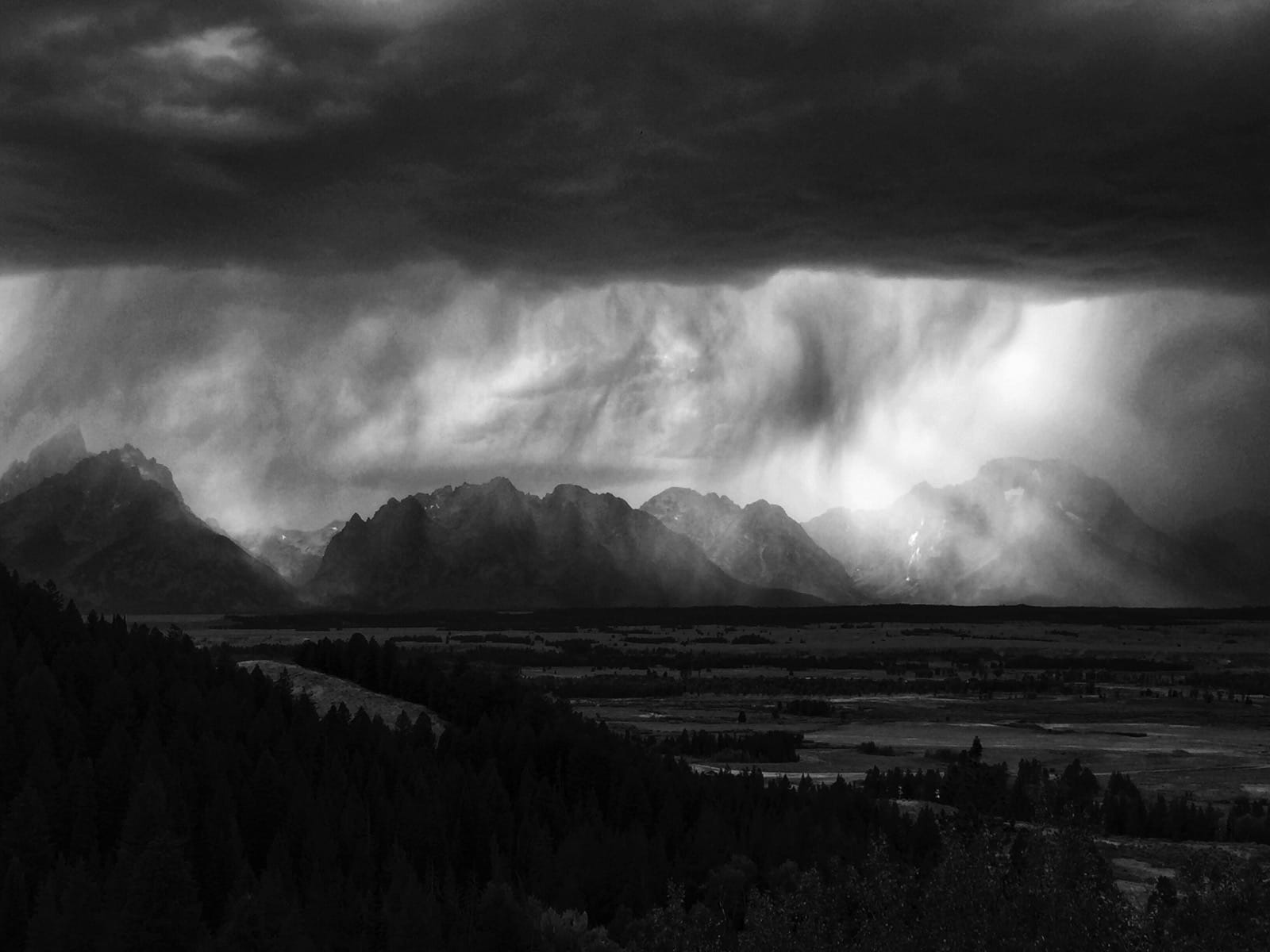B&W photo of rain falling on the Grand Tetons.